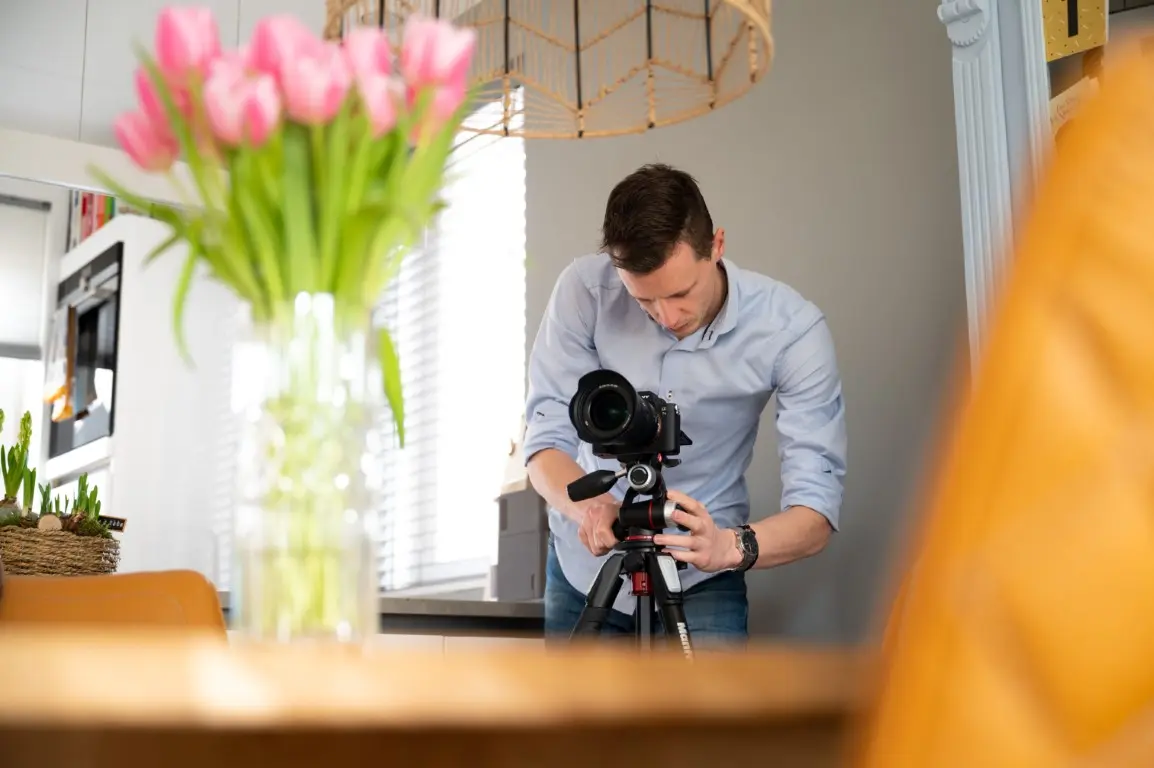 Fotograaf van ons mediateam legt een woonkamer vast met een camera op statief