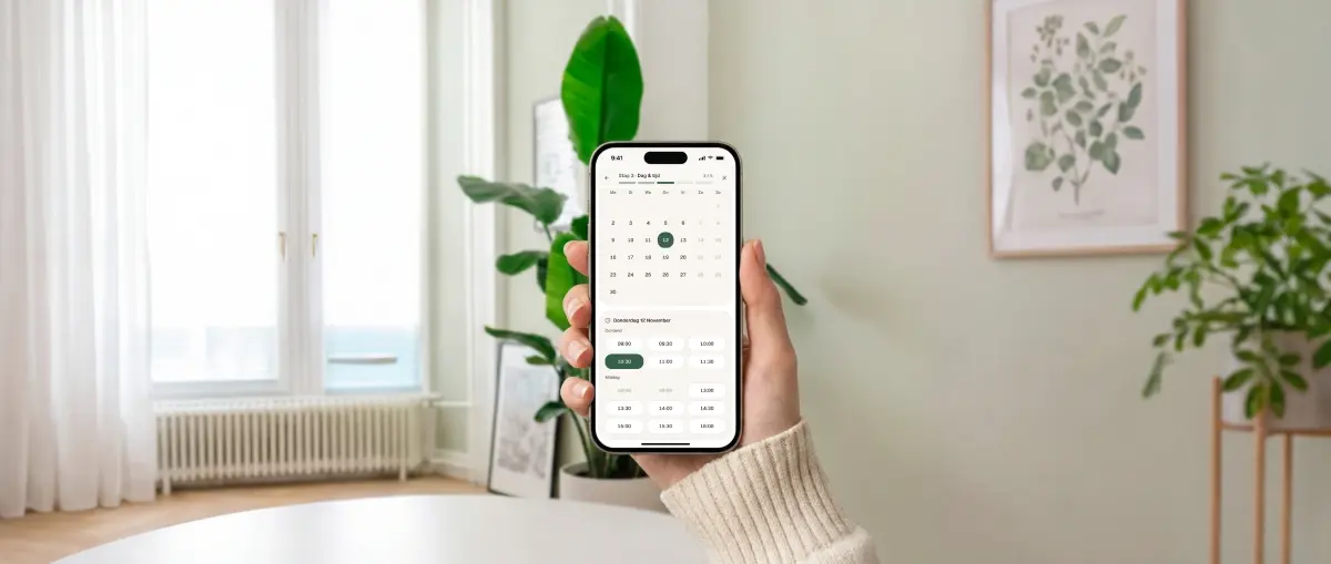Hand met een telefoon waarop de afspraakmodule openstaat bij het kiezen van een dag en tijd